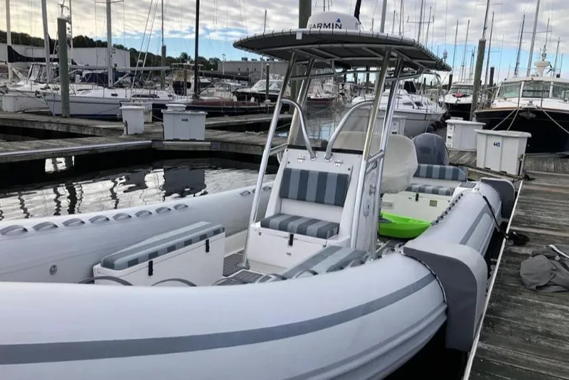 Slide: The Image of 2014 AB Inflatables Oceanus 28 VST boat docked at marina, featuring striped seating. - 6