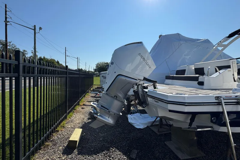 Slide: The Image of 2026 Monterey M-65 boat with Mercury engine, parked outdoors near a fence. - 6