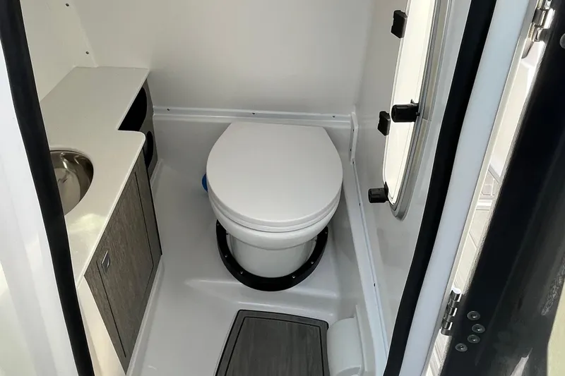 Slide: The Image of Compact bathroom in 2026 Monterey M-65 boat with toilet, sink, and storage cabinet. - 9
