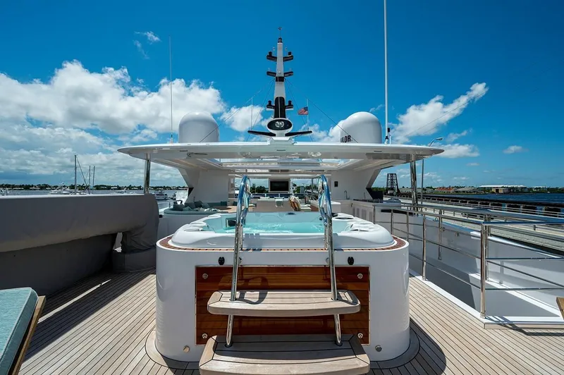Slide: The Image of Luxury Majesty 140 yacht deck with jacuzzi, 2020 model, under clear blue sky. - 11