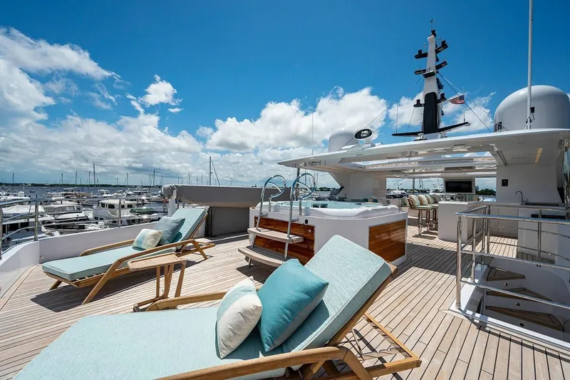 Slide: The Image of Luxurious 2020 Majesty 140 yacht deck with sun loungers and jacuzzi under blue sky. - 13