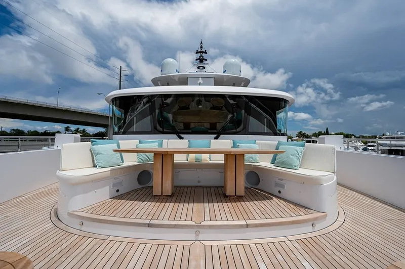 Slide: The Image of Luxurious 2020 Majesty 140 yacht deck with seating and table under cloudy sky. - 17