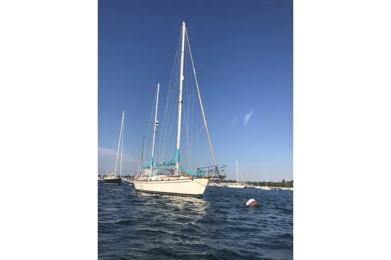 Slide: The Image of 1984 Shannon 51' Center Cockpit sailboat on calm water under clear blue sky. - 3