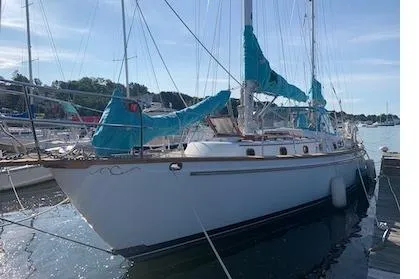 Slide: The Image of 1984 Shannon 51' Center Cockpit sailboat docked, featuring blue sail covers and classic design. - 7