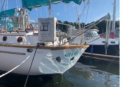 Slide: The Image of 1984 Shannon 51' Center Cockpit sailboat docked in a marina, featuring teal accents. - 8