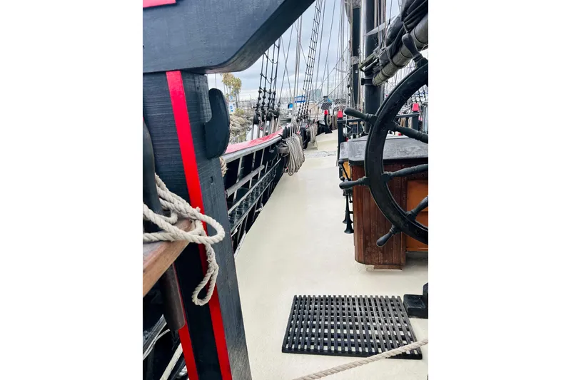Slide: The Image of 1977 Custom Brigantine ship deck with ropes and steering wheel, showcasing nautical details. - 10