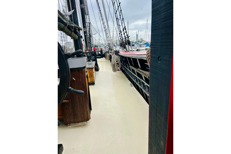 Slide: The Image of Deck view of a 1977 Custom Brigantine ship, showcasing rigging and wooden elements. - 11