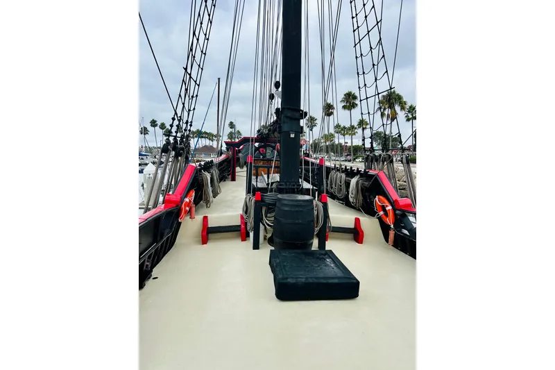Slide: The Image of 1977 Custom Brigantine ship deck with ropes and rigging, docked near palm trees. - 13
