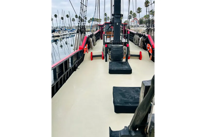 Slide: The Image of 1977 Custom Brigantine ship deck with ropes and lifebuoys, docked at a marina. - 15