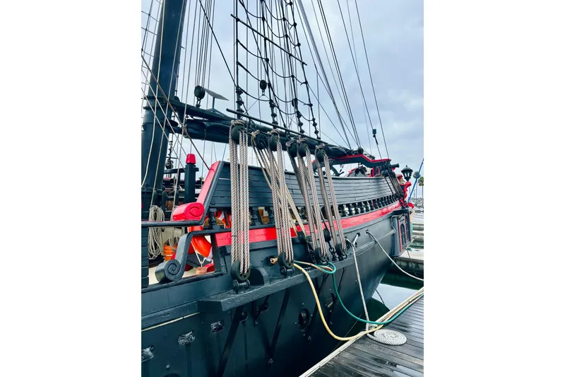 Slide: The Image of Vintage 1977 Custom Brigantine ship docked, showcasing intricate rigging and classic design. - 18
