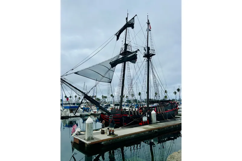Slide: The Image of Vintage 1977 Custom Brigantine ship docked at a marina with overcast skies. - 2