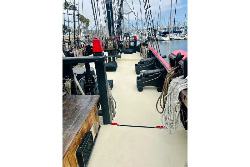 Slide: The Image of Deck view of a 1977 Custom Brigantine ship with ropes and cannons. - 20