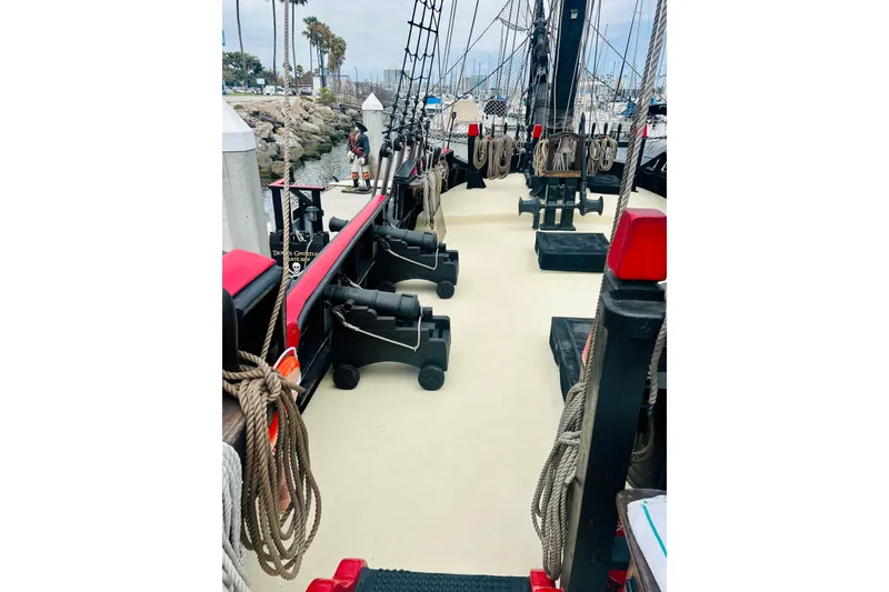 Slide: The Image of Deck view of a 1977 Custom Brigantine ship with ropes and cannons. - 21