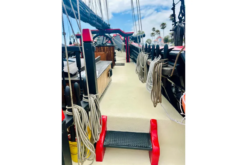 Slide: The Image of Deck view of a 1977 Custom Brigantine ship with ropes and red accents. - 22