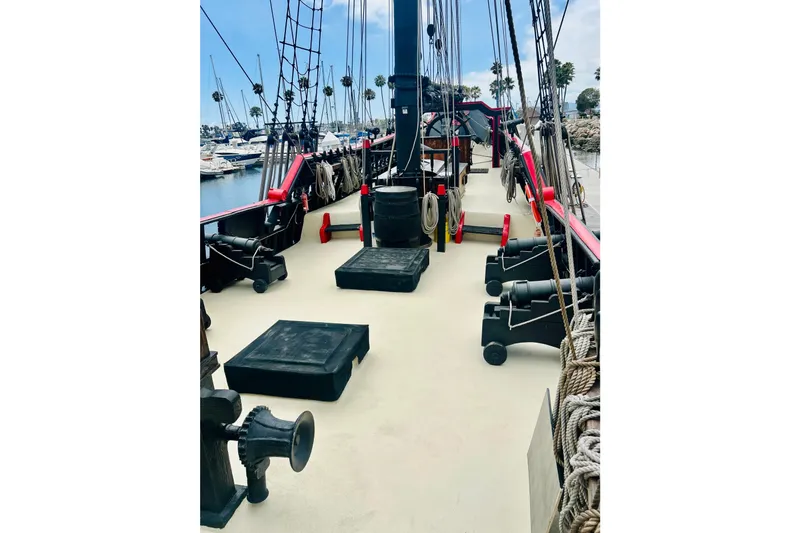 Slide: The Image of 1977 Custom Brigantine ship deck with cannons, ropes, and marina view. - 26