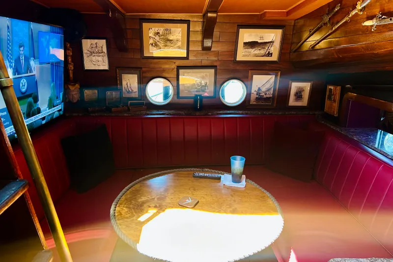 Slide: The Image of Cozy 1977 Custom Brigantine interior with nautical decor, red seating, and framed ship artwork. - 29