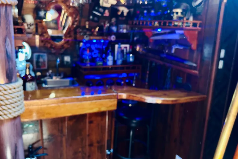 Slide: The Image of Rustic nautical-themed bar with wooden decor and blue lighting, featuring a 1977 Custom Brigantine style. - 30
