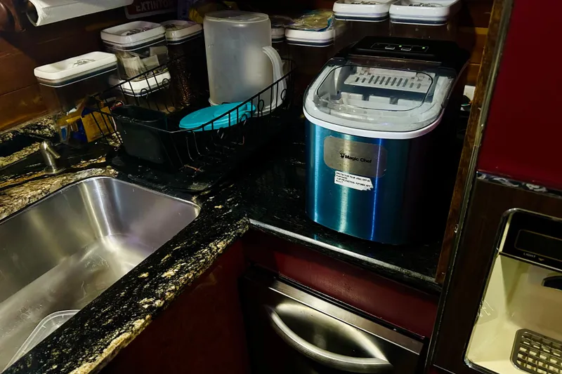 Slide: The Image of Kitchen counter with Magic Chef appliance, sink, and dish rack on a 1977 Custom Brigantine. - 41