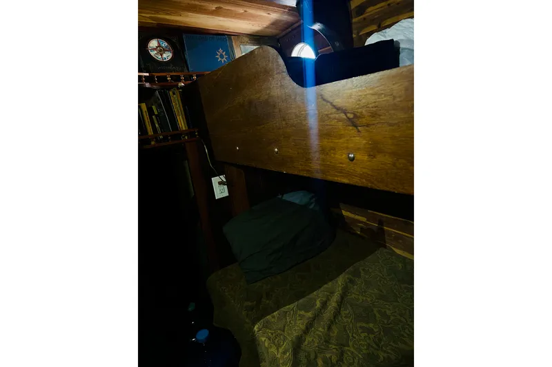 Slide: The Image of Cozy cabin interior of a 1977 Custom Brigantine with wooden bunk and bookshelves. - 48