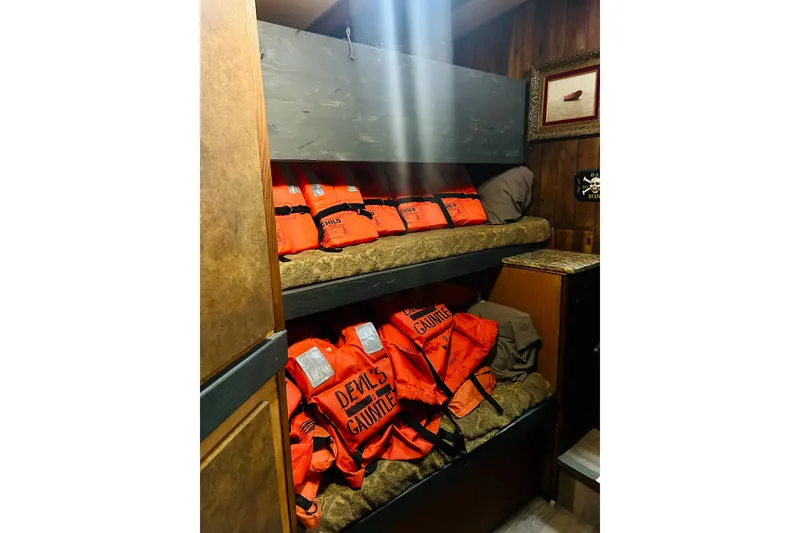 Slide: The Image of Bunk beds with orange life jackets labeled "Devil's Gauntlet" on a 1977 Custom Brigantine. - 51