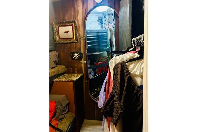 Slide: The Image of Interior of a 1977 Custom Brigantine with wooden walls, mirror, and hanging clothes. - 54