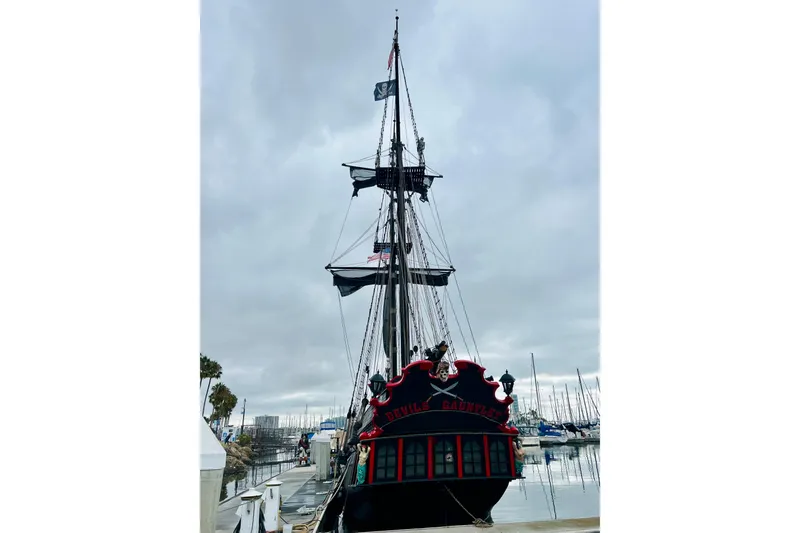 Slide: The Image of Vintage 1977 Custom Brigantine ship docked, featuring pirate-themed decor and flags. - 7