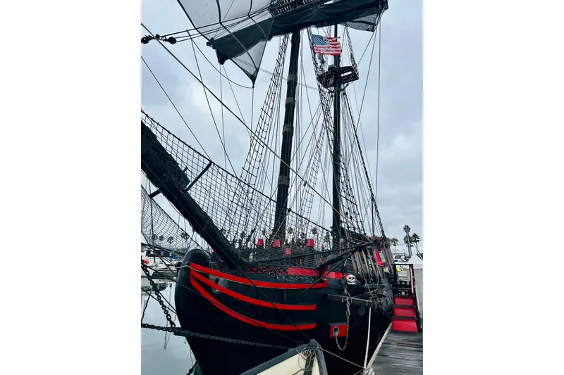 Slide: The Image of Vintage 1977 Custom Brigantine ship with red accents docked at a marina. - 8