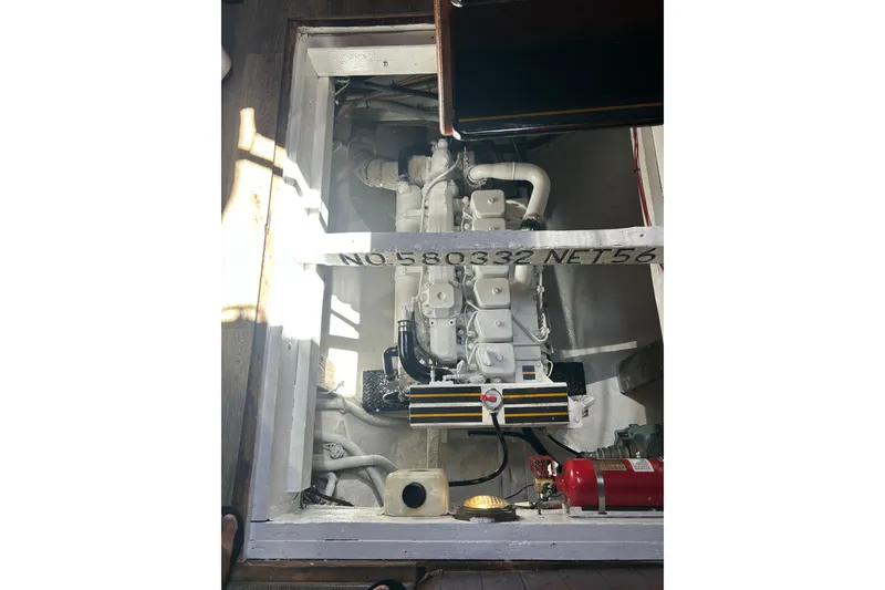 Slide: The Image of Engine compartment of a 1977 Custom 80 Brigantine boat, featuring visible machinery and fire extinguisher. - 63