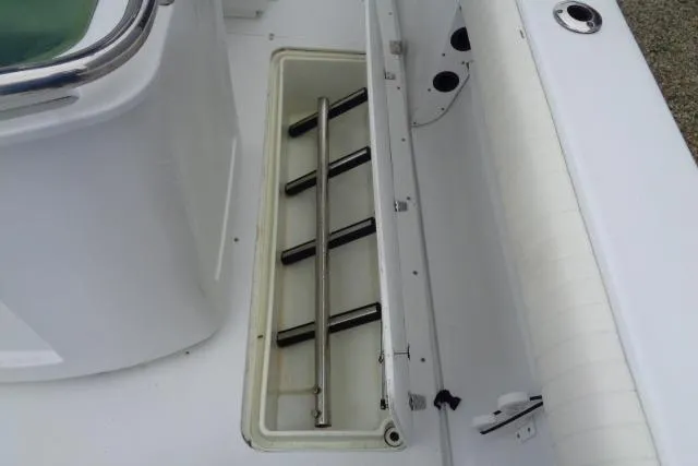 Slide: The Image of 2008 Triumph 235 CC boat interior with open storage compartment and rod holders. - 15