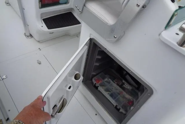 Slide: The Image of Open storage compartment on 2008 Triumph 235 CC boat, revealing organized tackle box. - 22