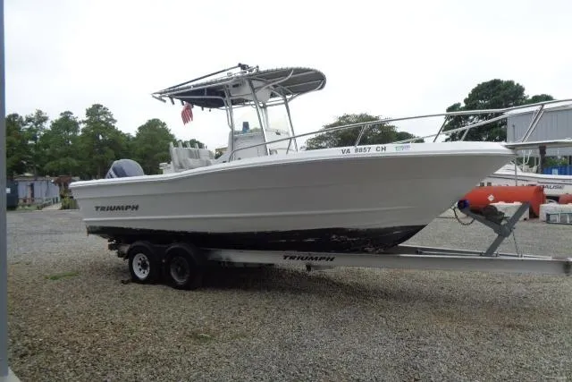 Slide: The Image of 2008 Triumph 235 CC boat on trailer, parked outdoors, side view. - 4