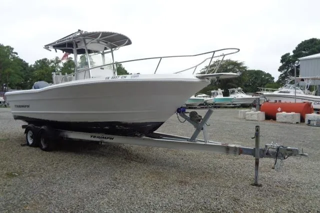 Slide: The Image of 2008 Triumph 235 CC boat on trailer, parked on gravel lot. - 5