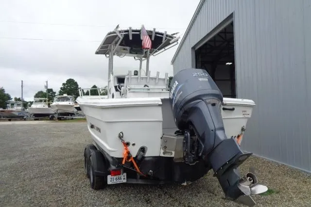 Slide: The Image of 2008 Triumph 235 CC boat with Yamaha 250 engine, parked near a metal building. - 6