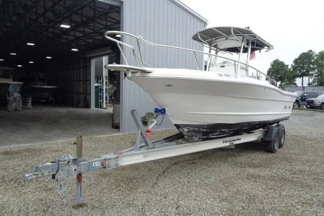 Slide: The Image of 2008 Triumph 235 CC boat on trailer outside a metal building. - 8