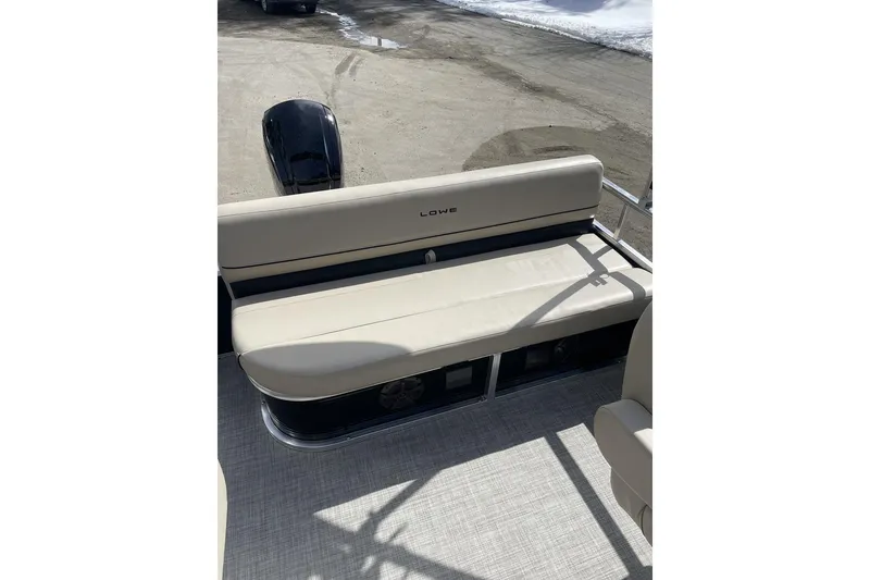Slide: The Image of 2024 Lowe Ultra 202 Fish & Cruise boat with beige seating and outboard motor. - 19