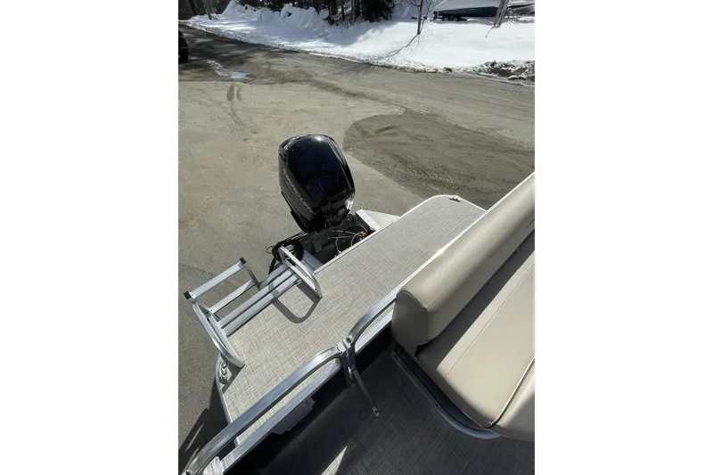 Slide: The Image of 2024 Lowe Ultra 202 Fish & Cruise boat with motor and seating, parked on snowy pavement. - 20