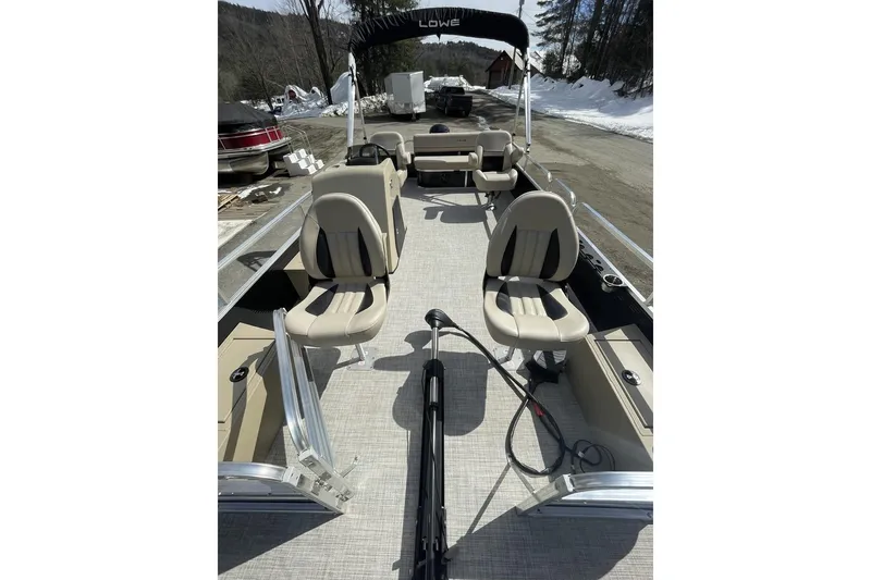 Slide: The Image of 2024 Lowe Ultra 202 Fish & Cruise pontoon boat with beige seating and open deck. - 9