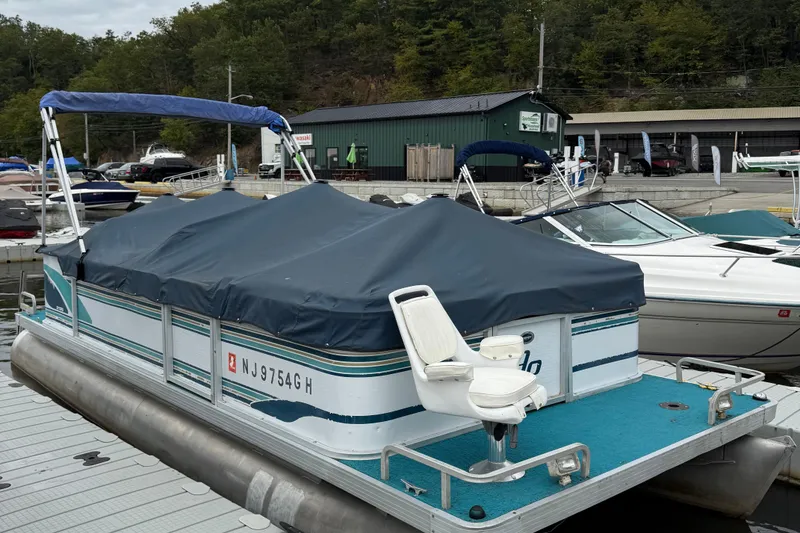 Slide: The Image of 1998 AquaPatio 210RS pontoon boat docked with cover, featuring a white seat. - 3