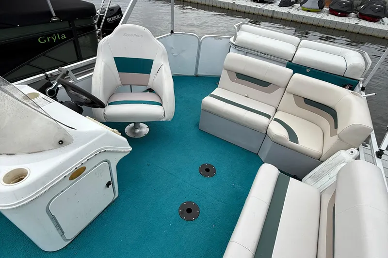 Slide: The Image of Interior of a 1998 AquaPatio 210RS boat with teal and white seating. - 6