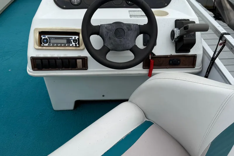Slide: The Image of Steering console of 1998 AquaPatio 210RS boat with controls and seating. - 8