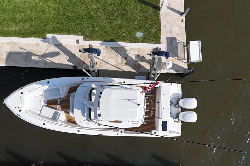 Slide: The Image of Overhead view of 2018 Everglades 335 Center Console boat docked by grassy area. - 14