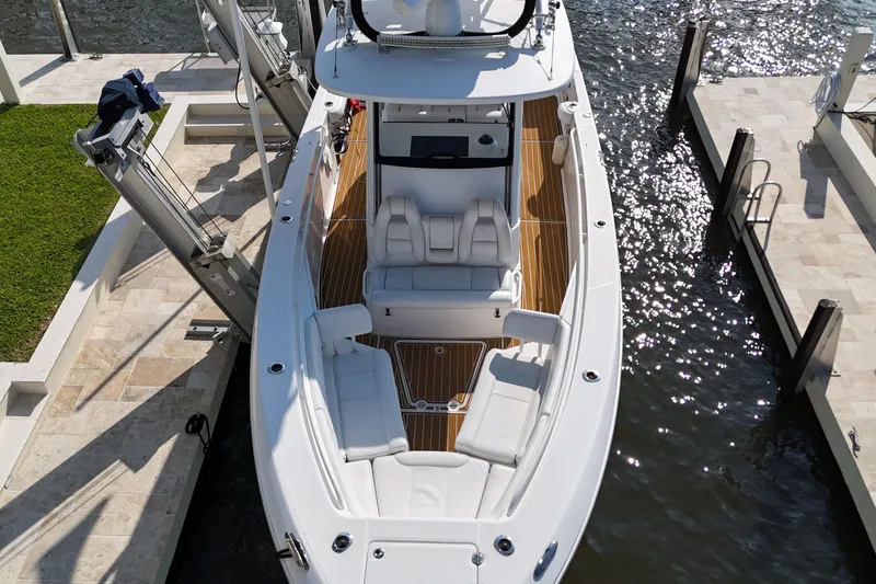 Slide: The Image of 2018 Everglades 335 Center Console boat docked, featuring spacious seating and sleek design. - 15