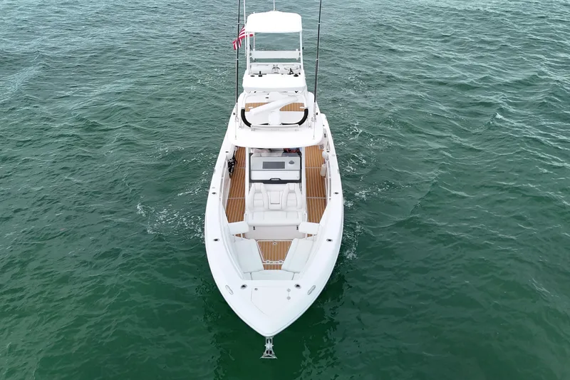 Slide: The Image of 2018 Everglades 335 Center Console boat on open water, aerial view. - 2