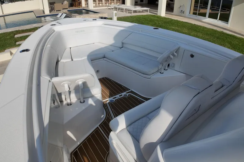 Slide: The Image of 2018 Everglades 335 Center Console boat interior with white seating and wood flooring. - 23