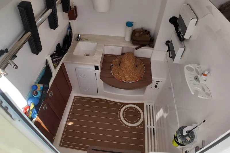 Slide: The Image of 2018 Everglades 335 Center Console cabin interior with sink, storage, and accessories. - 33