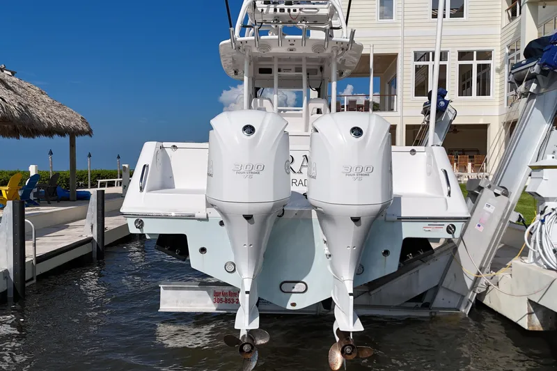 Slide: The Image of 2018 Everglades 335 Center Console boat with dual Yamaha 300 engines docked by a waterfront home. - 36