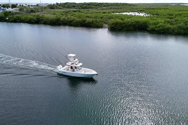 Slide: The Image of 2018 Everglades 335 Center Console boat cruising on a serene waterway. - 40