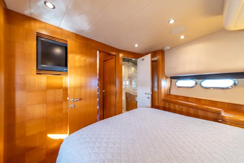 Slide: The Image of Luxurious 2009 Horizon 73 yacht bedroom with wood paneling and porthole windows. - 26