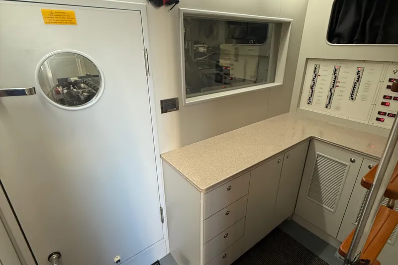 Slide: The Image of Engine room of 2009 Horizon 73 yacht with control panels and storage cabinets. - 56