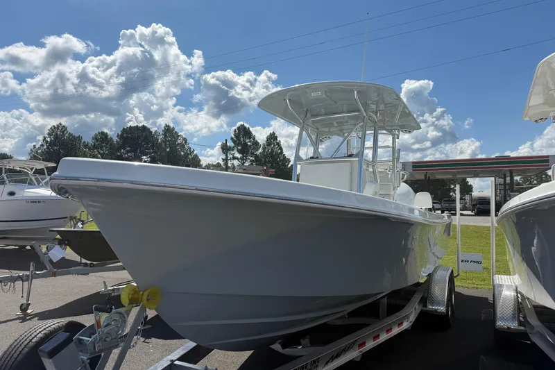 The Image of 2026 Pair Customs 27 Center Console boat on trailer under a sunny sky. - 0